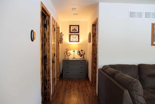 corridor featuring dark wood finished floors and visible vents