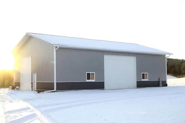 snow covered structure featuring an outbuilding