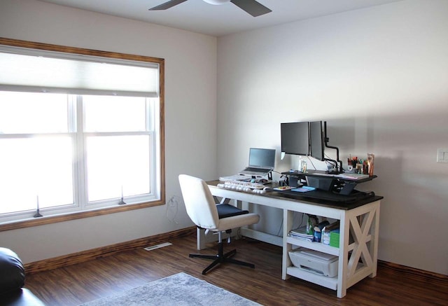 office space with dark wood-style floors, a healthy amount of sunlight, ceiling fan, and baseboards