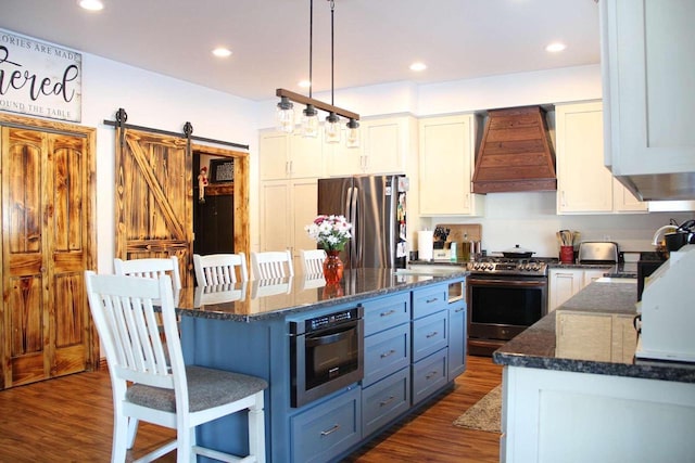 kitchen featuring a breakfast bar area, stainless steel appliances, dark wood-type flooring, white cabinets, and custom range hood