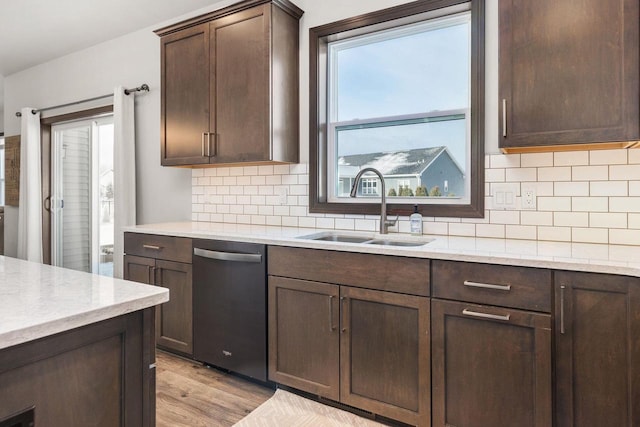 kitchen featuring backsplash, dark brown cabinetry, a sink, light wood-type flooring, and dishwasher