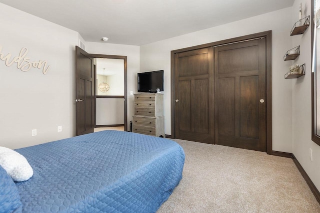 bedroom with a closet, carpet flooring, and baseboards