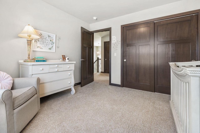 sitting room with baseboards and light colored carpet