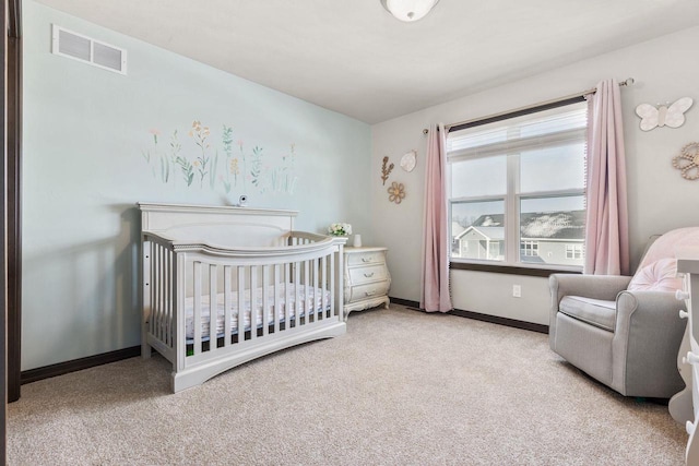 bedroom featuring carpet floors, a crib, visible vents, and baseboards