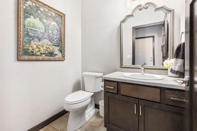 bathroom with toilet, baseboards, and vanity