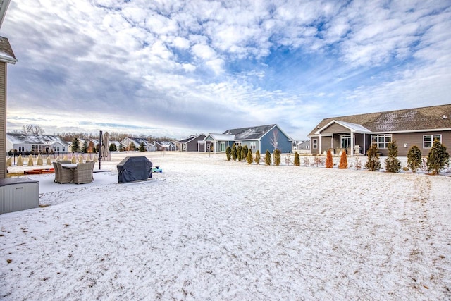 yard covered in snow featuring a residential view