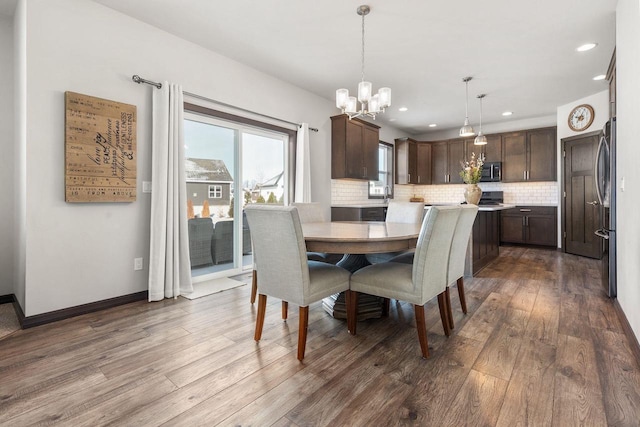 dining room featuring recessed lighting, dark wood finished floors, baseboards, and an inviting chandelier