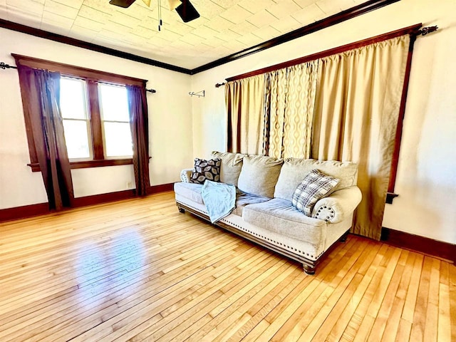 living room featuring wood-type flooring, crown molding, and baseboards