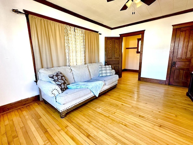 living room with a ceiling fan, crown molding, light wood-style flooring, and baseboards