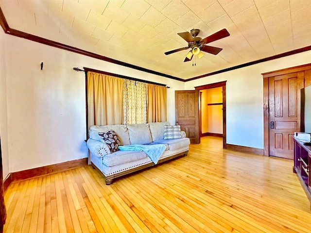 unfurnished living room with ornamental molding, light wood-style floors, and baseboards