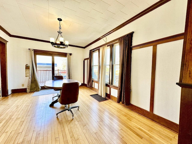 dining room featuring a chandelier, hardwood / wood-style floors, baseboards, and crown molding