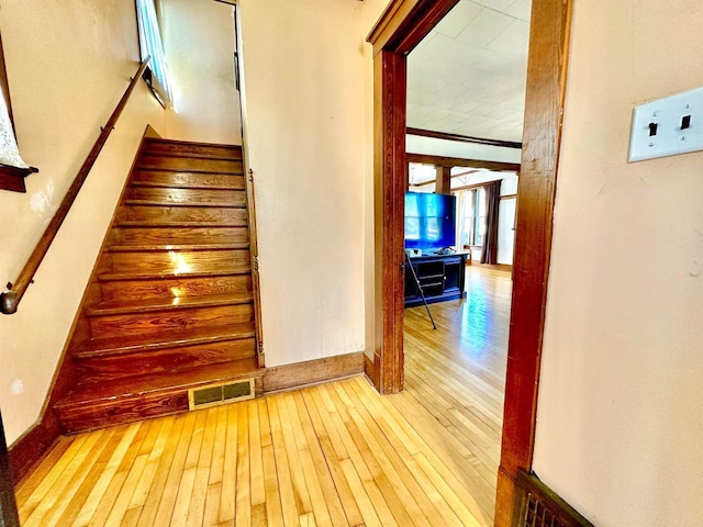 stairway featuring baseboards, visible vents, and hardwood / wood-style floors