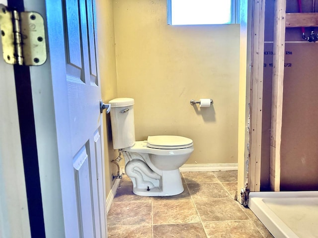 bathroom featuring baseboards and toilet