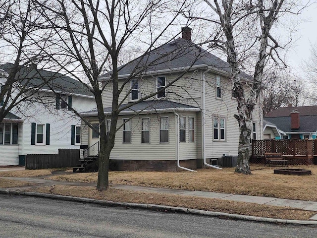 exterior space featuring entry steps, a chimney, a wooden deck, and central air condition unit