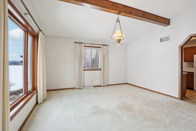 unfurnished room featuring baseboards, a healthy amount of sunlight, visible vents, and light colored carpet