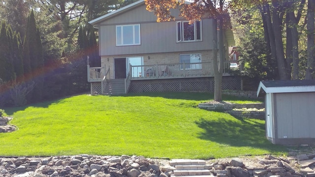 back of house with an outbuilding, a yard, a deck, and a storage shed