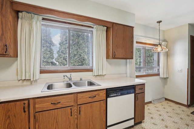 kitchen featuring baseboards, dishwasher, hanging light fixtures, light countertops, and a sink