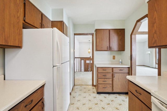 kitchen featuring brown cabinets, light countertops, and freestanding refrigerator