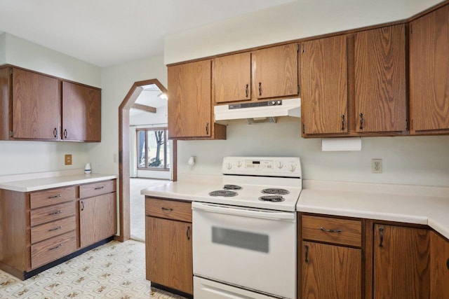 kitchen featuring white electric stove, light countertops, arched walkways, and under cabinet range hood