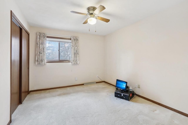 unfurnished bedroom with baseboards, ceiling fan, visible vents, and light colored carpet