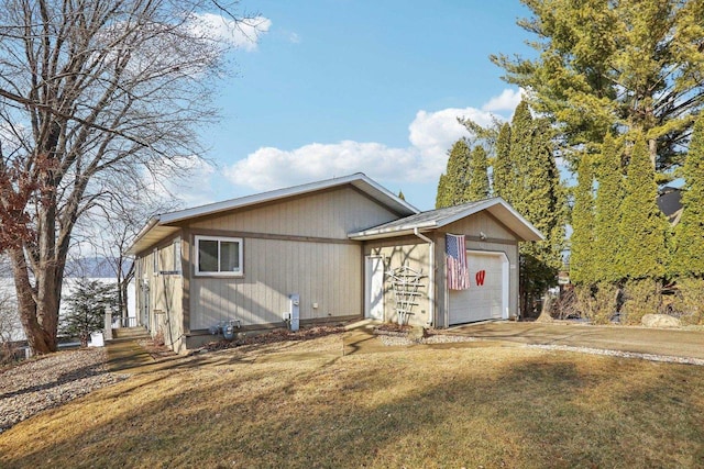 view of front of property featuring a front lawn, concrete driveway, and an attached garage