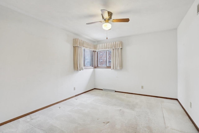 carpeted spare room featuring baseboards, visible vents, and a ceiling fan