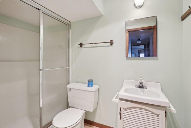 full bathroom featuring a shower stall, toilet, and vanity