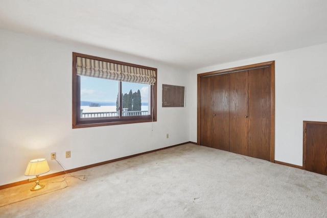 unfurnished bedroom featuring a closet, baseboards, and carpet flooring