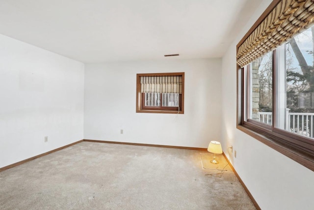 carpeted spare room with visible vents and baseboards