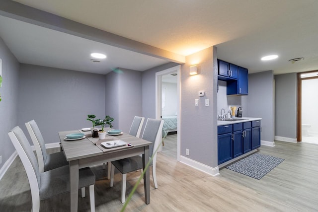 dining space with baseboards and light wood-style floors