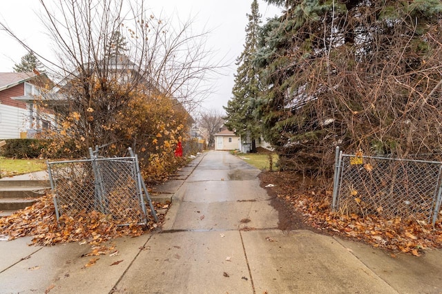 view of road with a gate, a gated entry, and concrete driveway