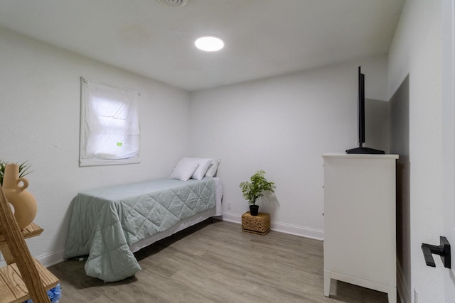 bedroom featuring baseboards and wood finished floors