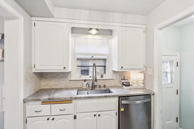 kitchen with a sink, tasteful backsplash, white cabinets, and stainless steel dishwasher