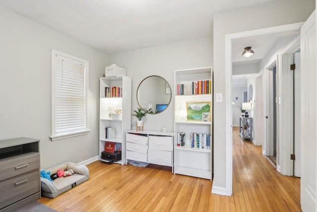 recreation room with baseboards and light wood-style floors