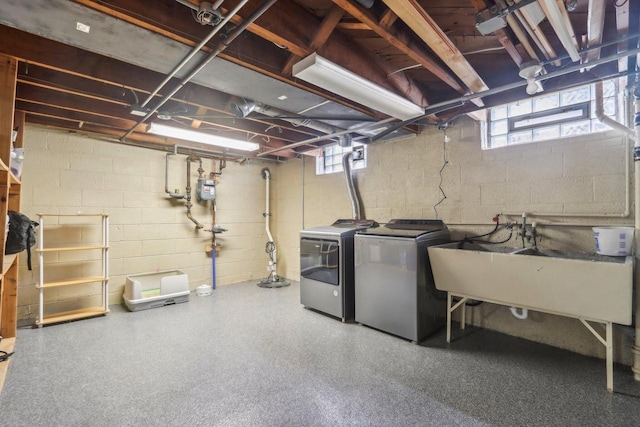 basement with separate washer and dryer and a sink