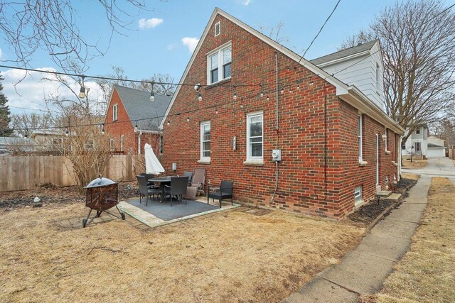 back of house with a patio, brick siding, and fence