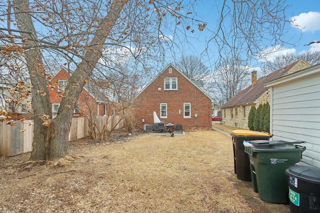 back of property with brick siding and fence