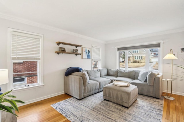 living area featuring ornamental molding, baseboards, and hardwood / wood-style flooring