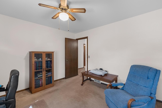 sitting room with light carpet, baseboards, and ceiling fan