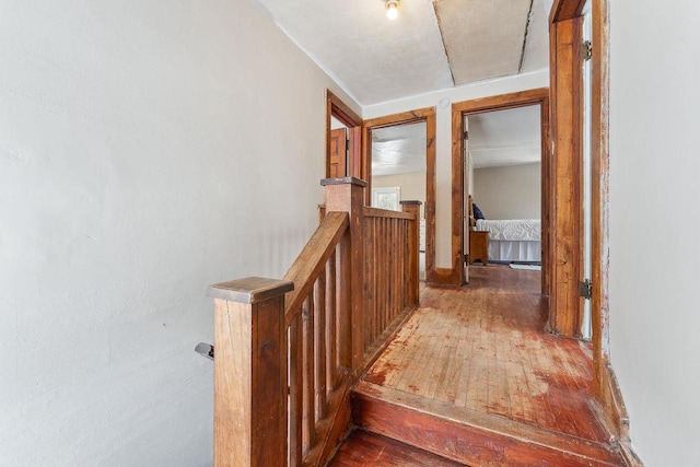 hall with hardwood / wood-style flooring and an upstairs landing