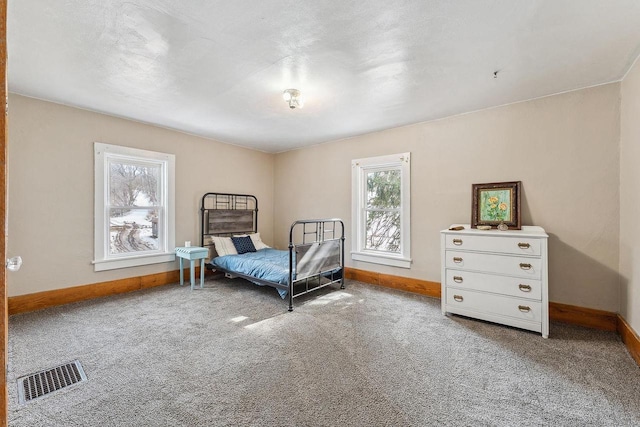 carpeted bedroom featuring visible vents and baseboards