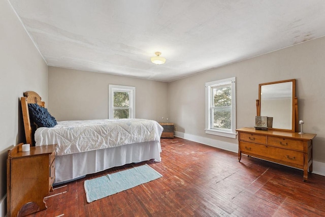 bedroom featuring hardwood / wood-style flooring, multiple windows, and baseboards