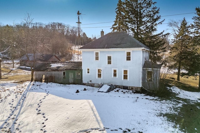 snow covered property featuring a chimney