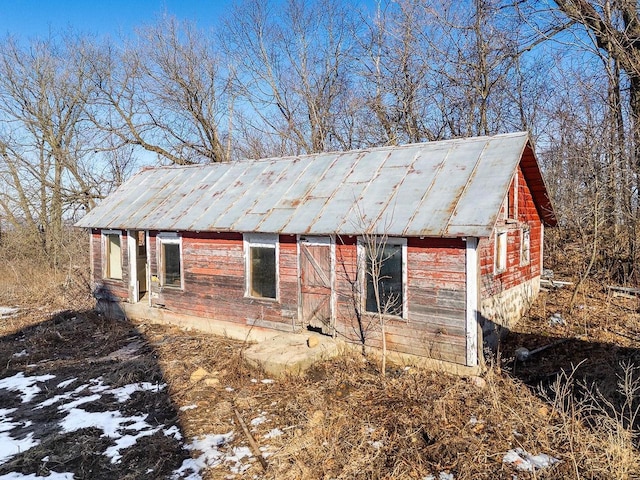 view of side of property with metal roof and an outdoor structure