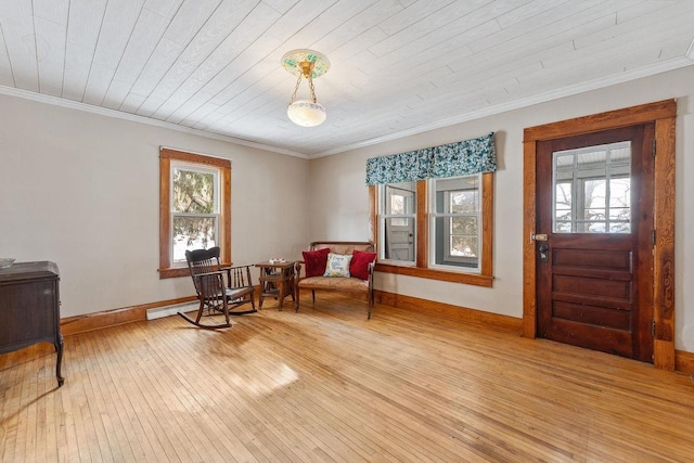 living area with baseboards, crown molding, light wood-style flooring, and baseboard heating