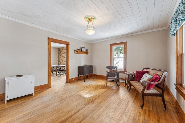 sitting room featuring ornamental molding, light wood-style flooring, and baseboards