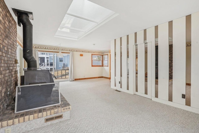 interior space with a wood stove, a skylight, carpet, and visible vents