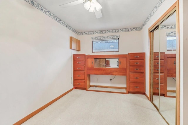 unfurnished bedroom with a ceiling fan, a closet, light carpet, and baseboards