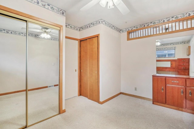 unfurnished bedroom featuring light carpet, ceiling fan, and baseboards