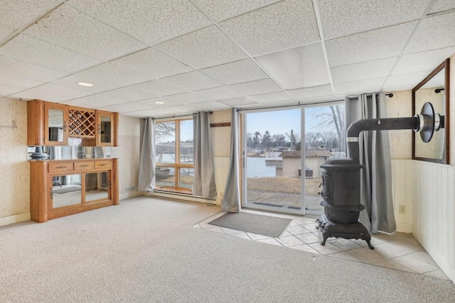 interior space with light carpet, a wainscoted wall, and a drop ceiling